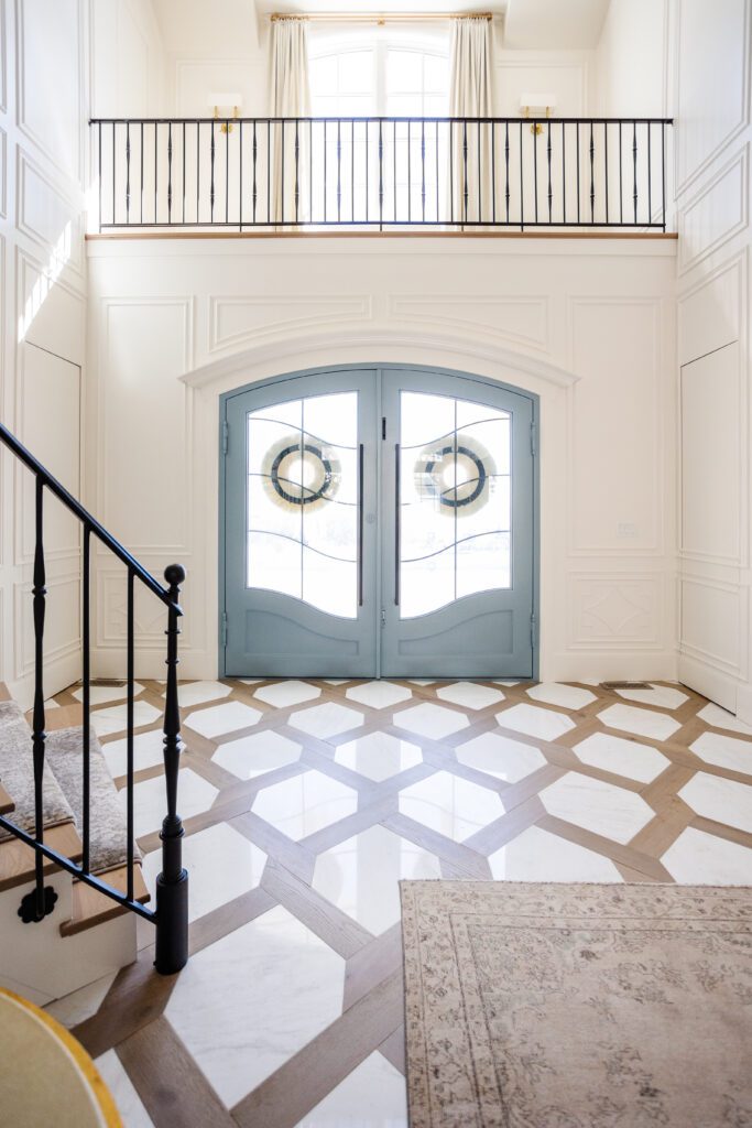 Home entry way featuring a marble and wood floor with a clipped diamon design